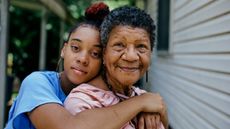 Portrait of black grandmother with teenager granddaughter both are looking into the camera. 