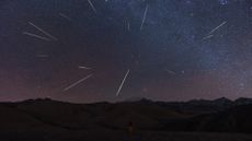 A long-exposure photo showing many meteors streaking across the night sky