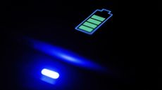 A battery symbol on a digital interface in the dark with a blue light on to indicate charging